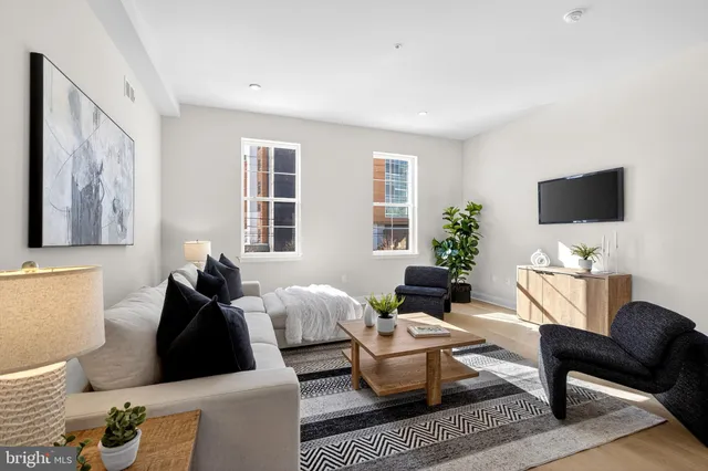 a living room with furniture a flat screen tv and a window