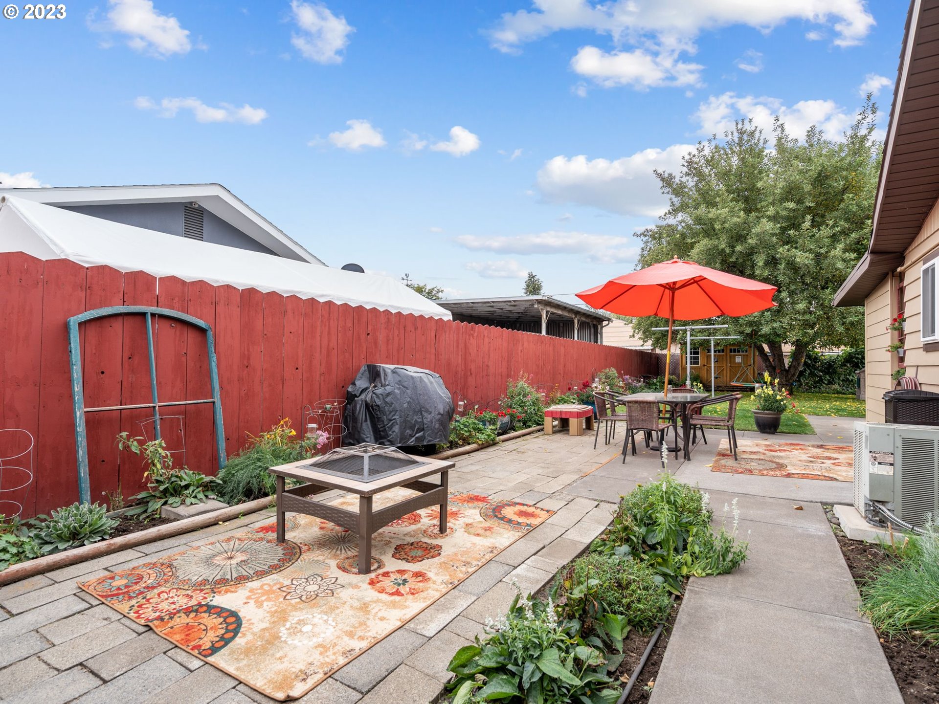 1341 Southwest 40th Street Pendleton, OR 97801 - Photo 5 of 35 a view of a patio with a table and chairs under an umbrella with a fire pit