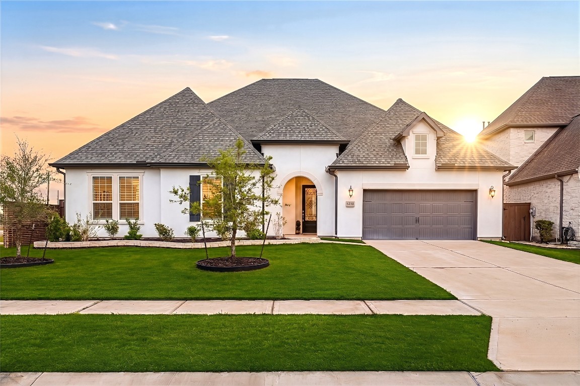 a front view of a house with a yard and garage
