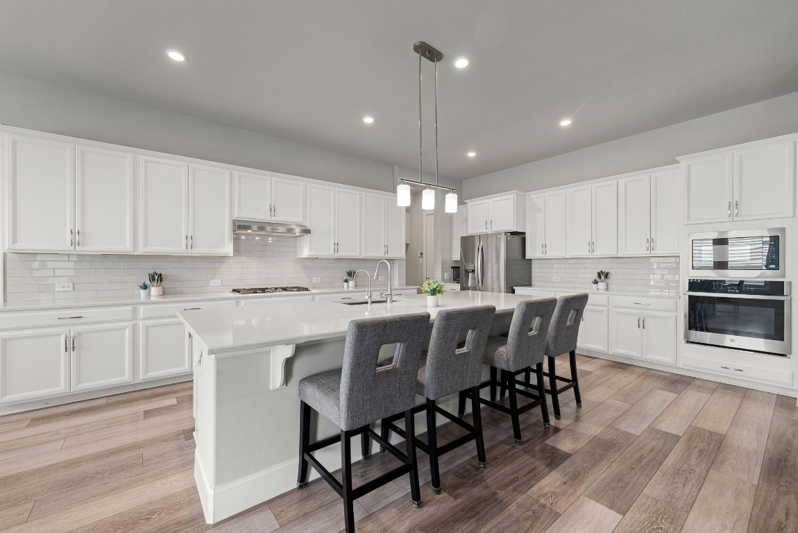 6203 Silver Lk Lane Manvel, TX 77578 - Photo 11 of 50 a kitchen with stainless steel appliances granite countertop a table chairs sink microwave and cabinets