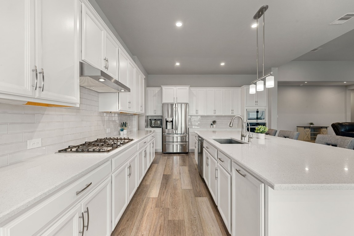 6203 Silver Lk Lane Manvel, TX 77578 - Photo 12 of 50 a large kitchen with stainless steel appliances granite countertop a lot of counter space and wooden floors