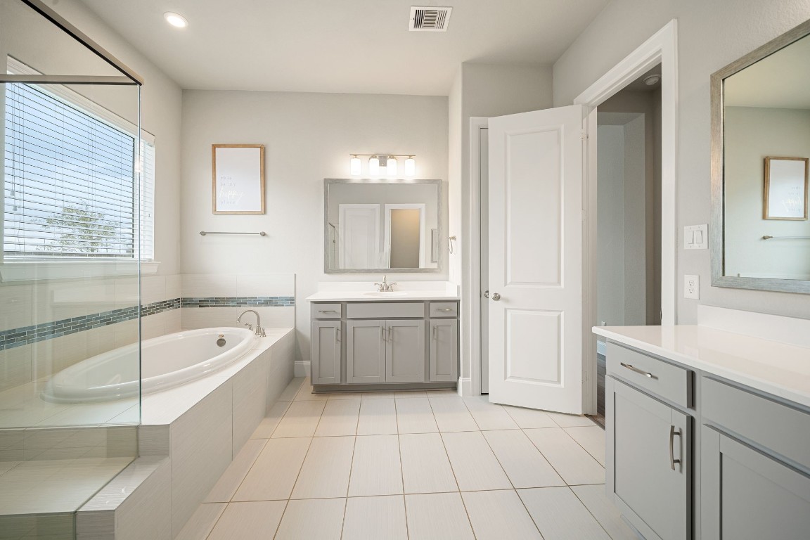 6203 Silver Lk Lane Manvel, TX 77578 - Photo 18 of 50 a bathroom with a tub a sink a mirror and a shower