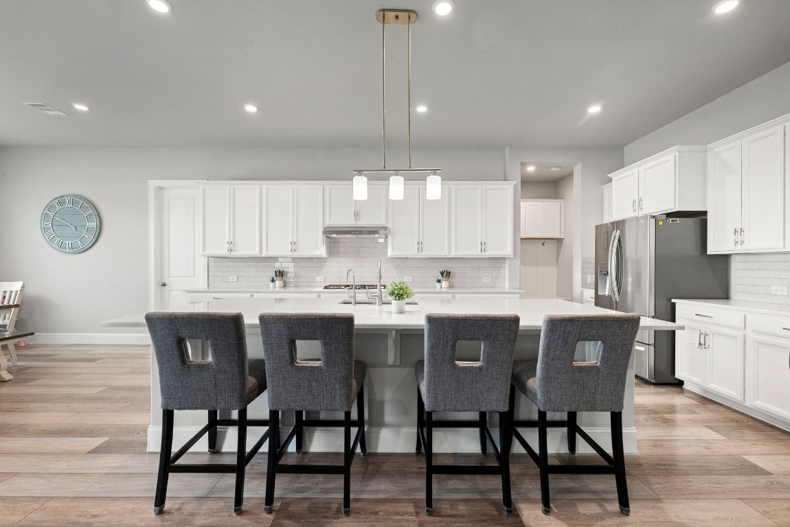 6203 Silver Lk Lane Manvel, TX 77578 - Photo 10 of 50 a kitchen with stainless steel appliances granite countertop a dining table chairs and white cabinets