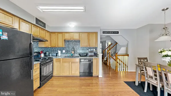 a kitchen with stainless steel appliances granite countertop a refrigerator a stove and a sink
