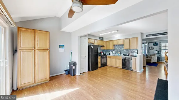 a view of a kitchen with refrigerator and wooden floor