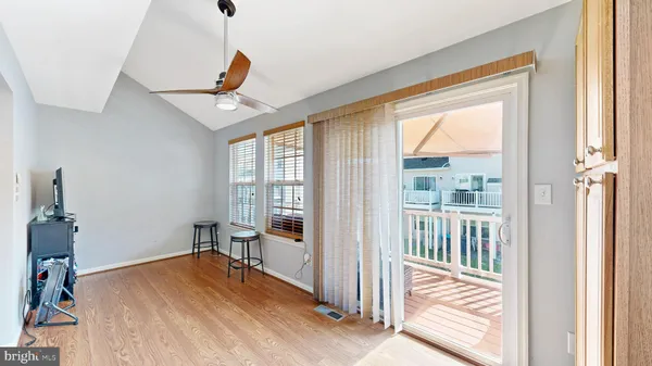 a view of a livingroom with wooden floor and a ceiling fan