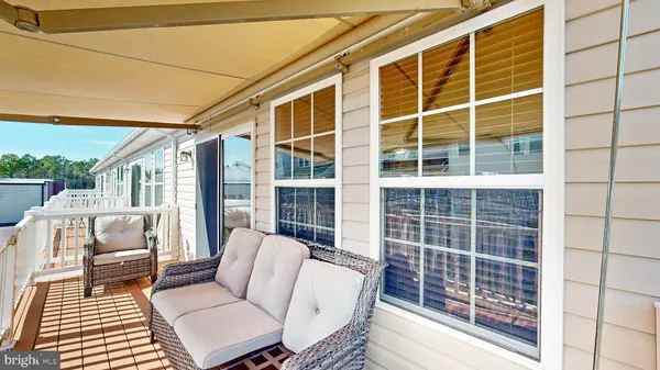 a view of a patio with couches chairs and wooden floor