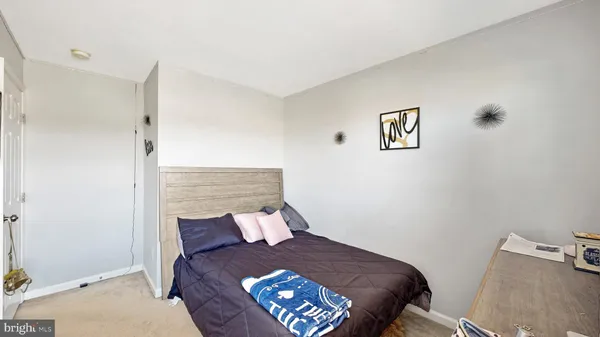 a bedroom with a bed and a painting on the wall