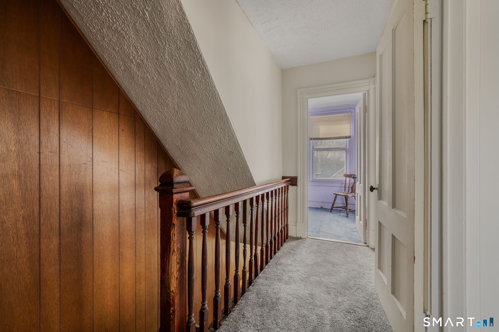 45 Dunham Street Norwich, CT 06360 - Photo 17 of 40 a view of a hallway to a livingroom with furniture and stairs