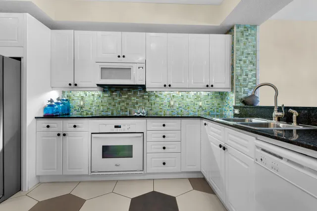 a kitchen with sink and white cabinets