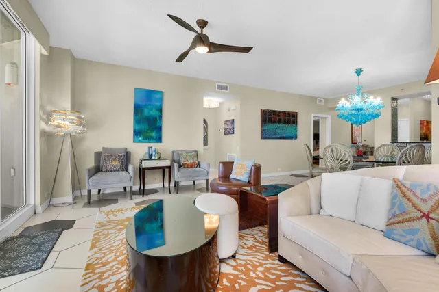 a living room with furniture a chandelier and a dining table