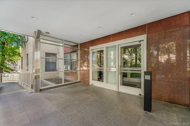 a view of an empty room with floor to ceiling window and an outdoor view