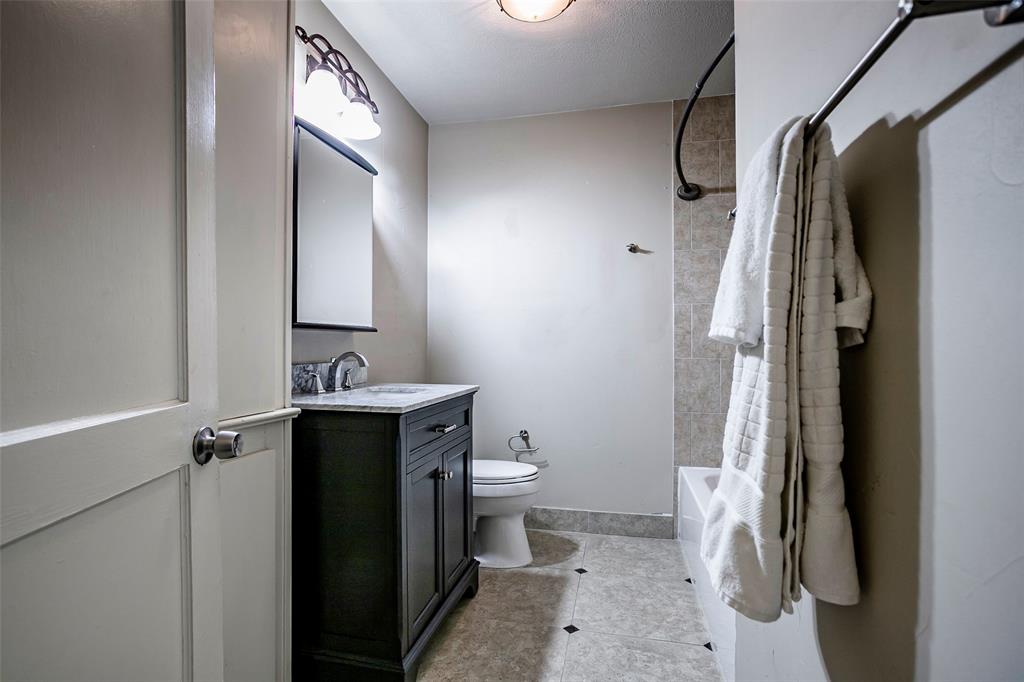 7410 Caillet Street Dallas, TX 75209 - Photo 18 of 25 a bathroom with a sink and a mirror