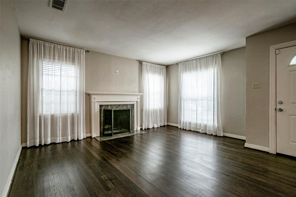 7410 Caillet Street Dallas, TX 75209 - Photo 5 of 25 an empty room with large windows and fireplace