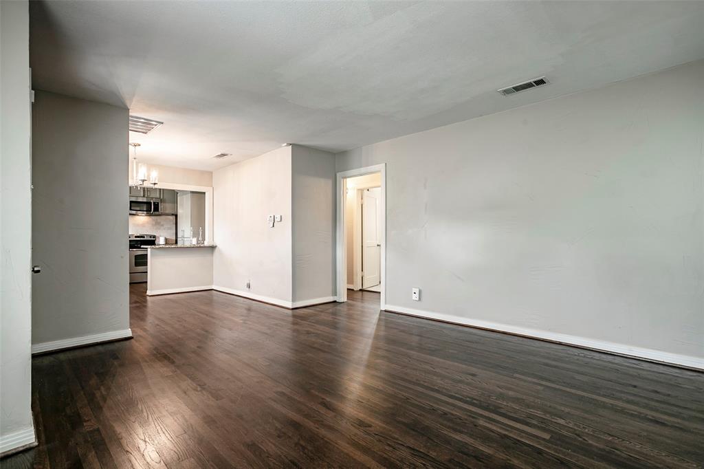 7410 Caillet Street Dallas, TX 75209 - Photo 7 of 25 a view of an empty room with wooden floor and a window