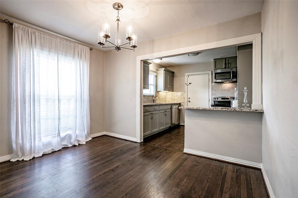7410 Caillet Street Dallas, TX 75209 - Photo 8 of 25 an empty room with wooden floor a ceiling fan and windows