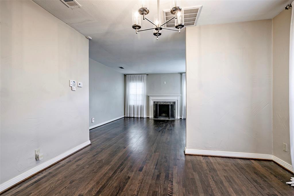 7410 Caillet Street Dallas, TX 75209 - Photo 9 of 25 a view of empty room with wooden floor and fireplace
