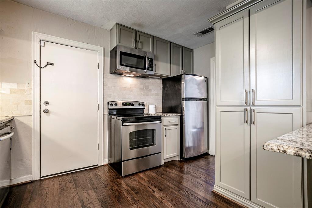 7410 Caillet Street Dallas, TX 75209 - Photo 10 of 25 a kitchen with stainless steel appliances a refrigerator sink and microwave