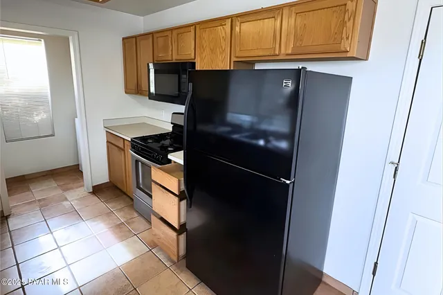 a kitchen with stainless steel appliances granite countertop a refrigerator and a stove