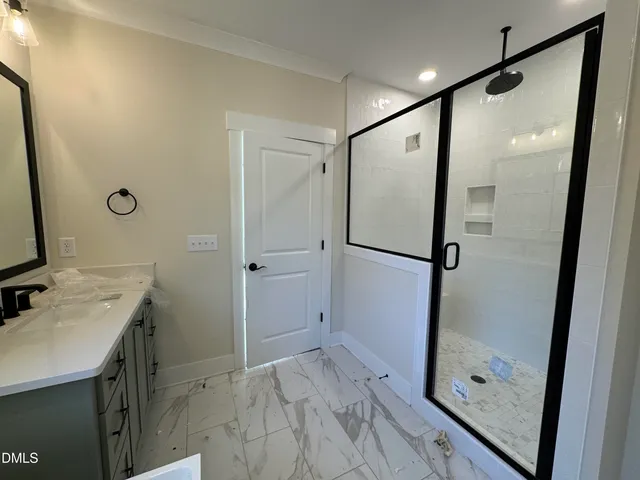 a bathroom with a shower sink and mirror