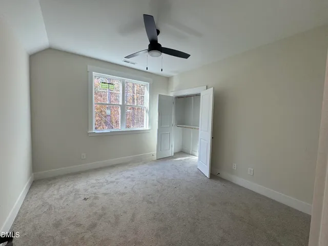 an empty room with windows and ceiling fan