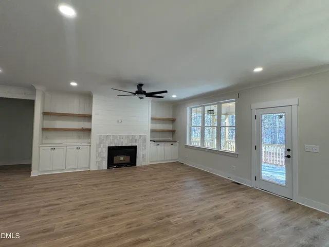 an empty room with windows and fireplace