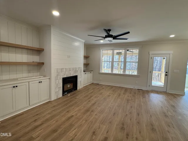 an empty room with windows and a fireplace