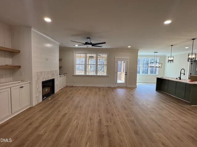 an empty room with wooden floor and fireplace