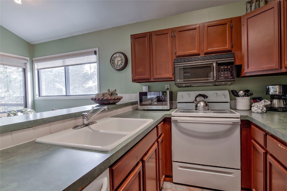 1977 Soda Ridge Road, Unit 1199 Keystone, CO 80435 - Photo 11 of 35 a kitchen with granite countertop a sink stainless steel appliances cabinets and a window
