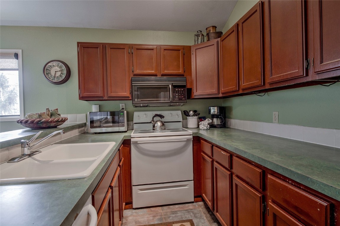 1977 Soda Ridge Road, Unit 1199 Keystone, CO 80435 - Photo 10 of 35 a kitchen with stainless steel appliances granite countertop a sink stove and microwave