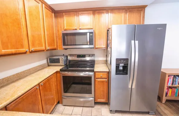 a kitchen with stainless steel appliances granite countertop a refrigerator and a sink