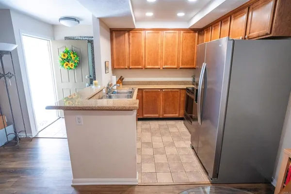 a kitchen with stainless steel appliances granite countertop a refrigerator a sink a stove a washer dryer and a window