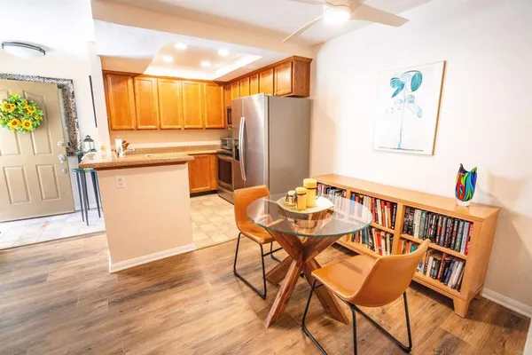a kitchen with stainless steel appliances wooden floor and dining table
