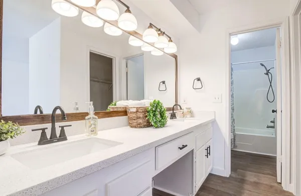 a bathroom with a double vanity sink mirror and shower