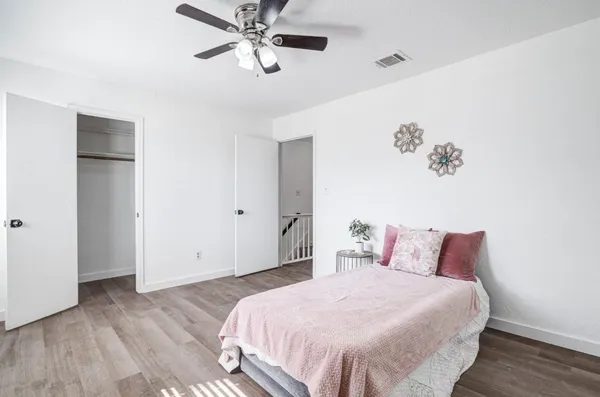 a bedroom with a bed and wooden floor