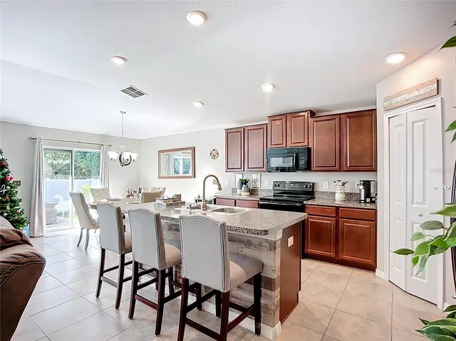 a kitchen with granite countertop a stove top oven a sink a counter space and cabinets
