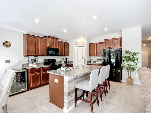 a spacious bedroom with a bed and a flat tv screen on dresser