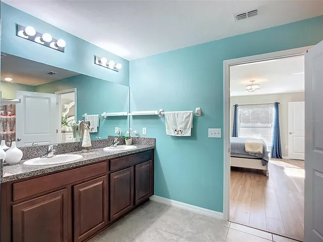 a spacious bedroom with a bed and a dresser