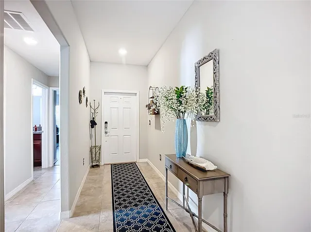 a living room with furniture kitchen view and a chandelier