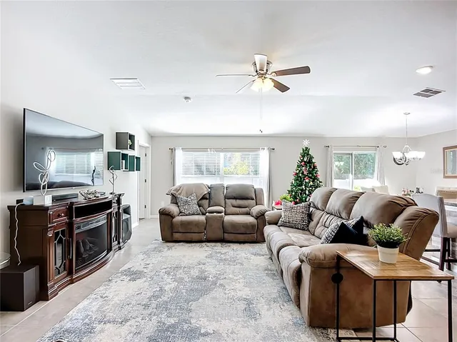 a living room with furniture a flat screen tv and a window