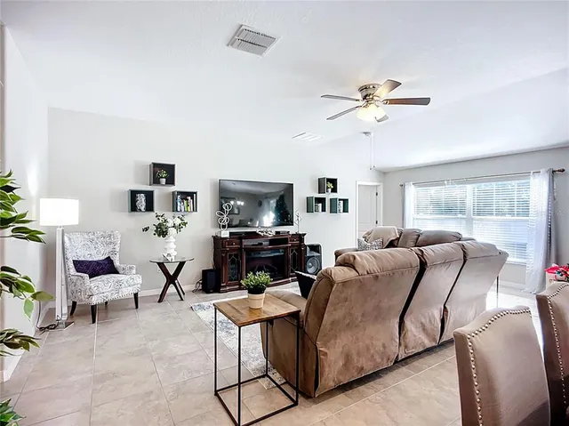 a living room with furniture a flat screen tv and a fireplace