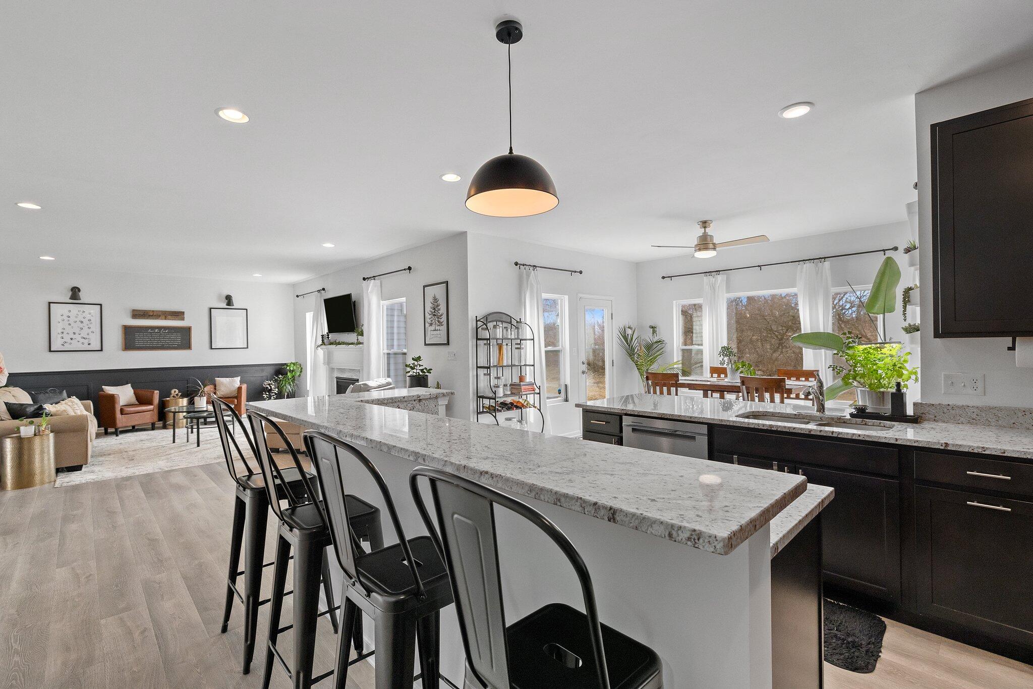 8766 Burr Rdg Circle Crown Point, IN 46307 - Photo 11 of 33 a kitchen with stainless steel appliances granite countertop a stove a sink a dining table and chairs with wooden floor
