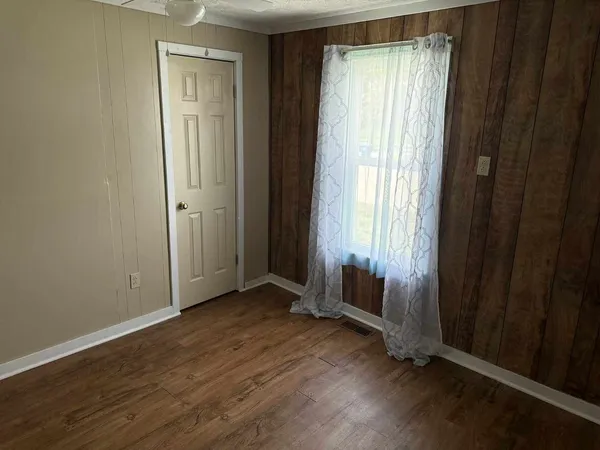 an empty room with wooden floor and a window