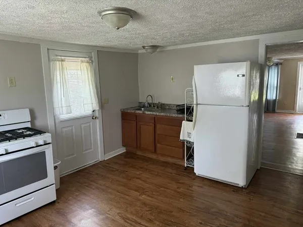 a kitchen with a refrigerator a stove a microwave and wooden floor