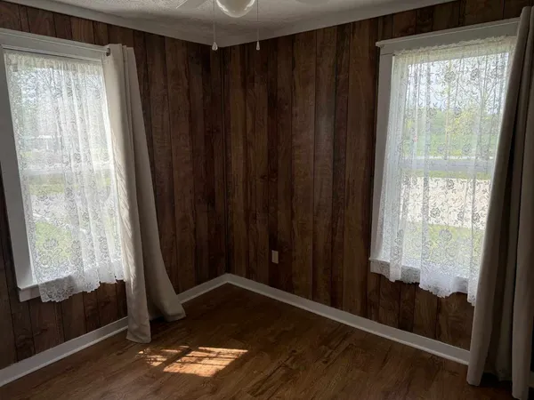 a view of a room with wooden floor and a window