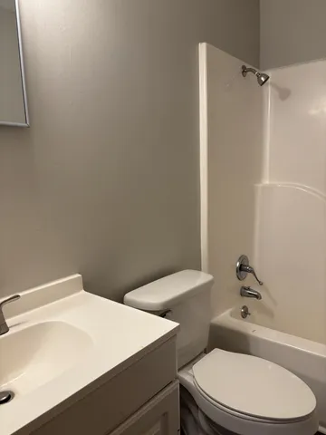 a white toilet sitting next to a bathroom sink