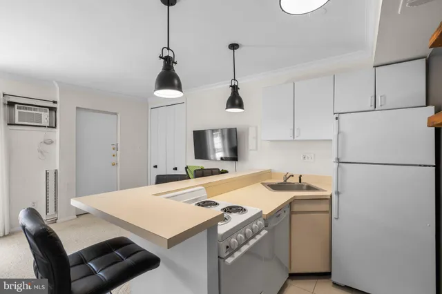 a kitchen that has a cabinets a refrigerator and a stove