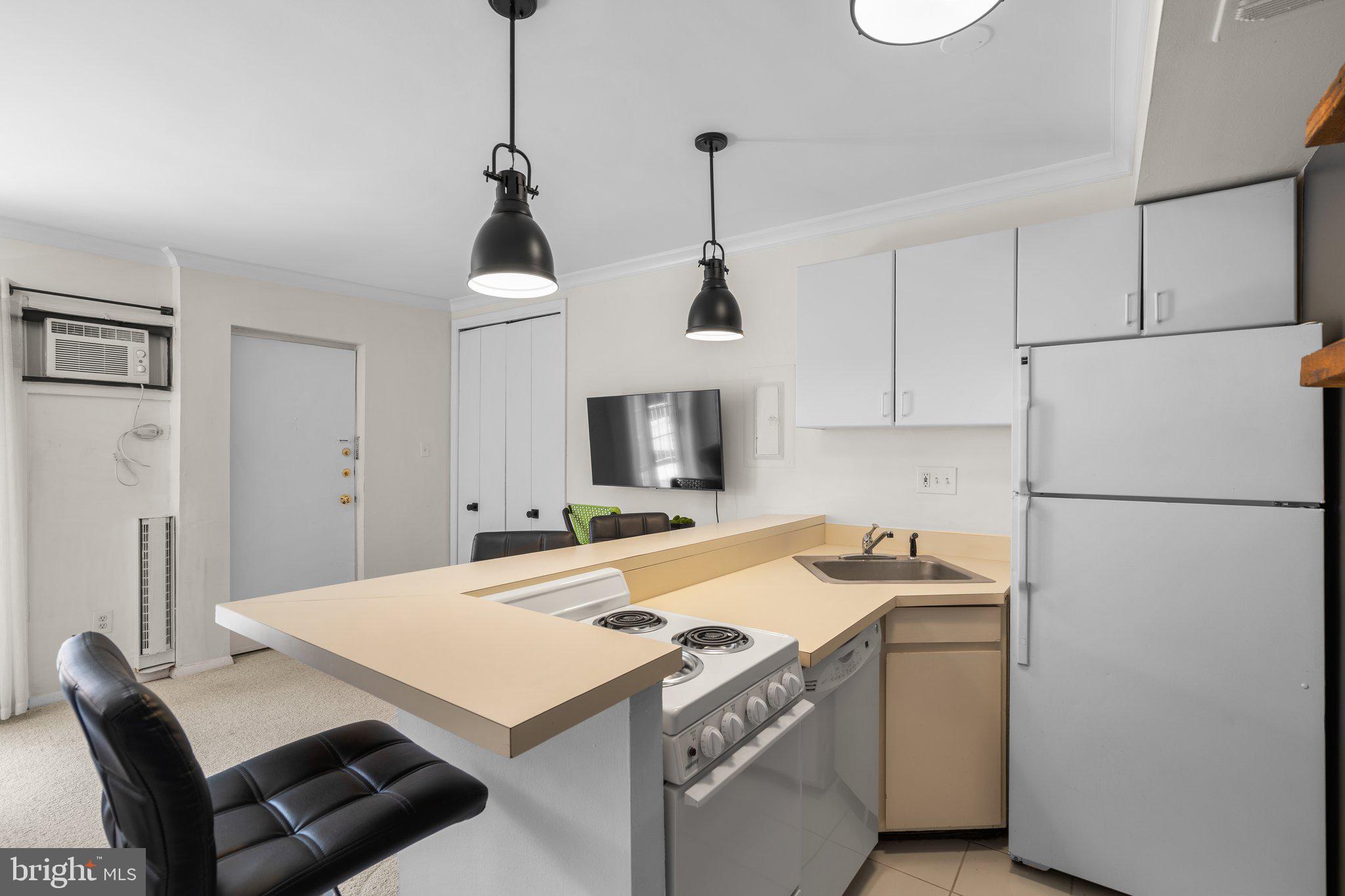 2515 P Street Northwest, Unit 302 Washington, DC 20007 - Photo 14 of 27 a kitchen that has a cabinets a refrigerator and a stove