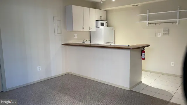 a kitchen with kitchen island a sink a stove and white cabinets