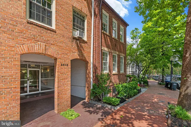 a view of a brick building next to a yard